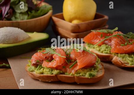 Pain à grains entiers avec pâte d'avocat et saumon, feuilles d'arugula. Banque D'Images