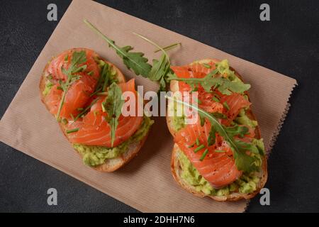 Pain à grains entiers avec pâte d'avocat et saumon, feuilles d'arugula. Banque D'Images