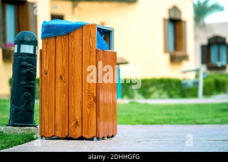 Des poubelles en bois jaune sont à l'extérieur sur le côté du trottoir dans le parc. Conteneur à ordures à l'extérieur. Banque D'Images