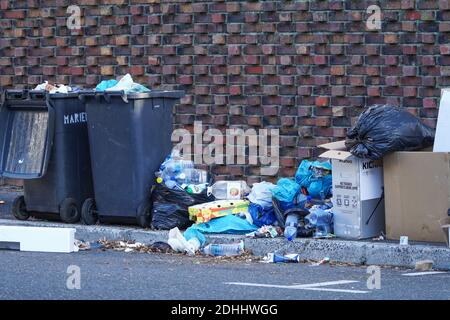 Litière à côté d'une poubelle, poubelles débordant sur le trottoir avec des ordures laissées dehors concept de pollution environnementale au Cap, Afrique du Sud Banque D'Images