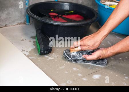 Lavez les baskets avec une brosse et du détergent à lessive. Banque D'Images