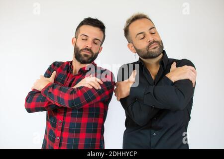 Jeune gay couple de deux hommes portant des vêtements décontractés s'embrassant heureux et positif, souriant confiant. Amour de soi et de soin de soi Banque D'Images