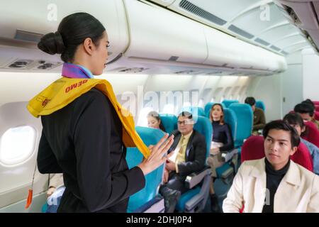 La compagnie aérienne Asian Air Hostess démontre les procédures de sécurité aux passagers avant le décollage du vol dans un avion de cabine. Banque D'Images