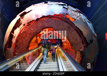 Des personnes se dirigeant vers le noyau de la terre dans le Earth Hall sur l'escalier roulant. The Earth Galleries, Red zone, Natural History Museum, Londres, Angleterre, Royaume-Uni Banque D'Images