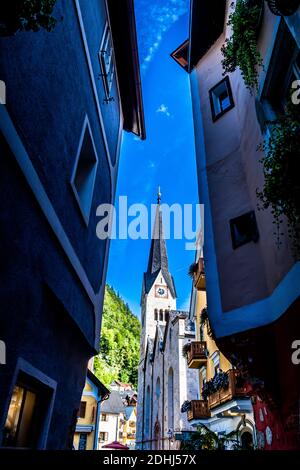 Allée étroite avec bâtiments historiques et vue sur l'église Ville pittoresque de Lakeside Hallstatt en Autriche Banque D'Images