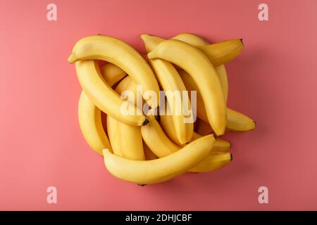 Bouquet frais de bananes jaunes isolées sur fond rose. Concept minimaliste. Espace libre Banque D'Images