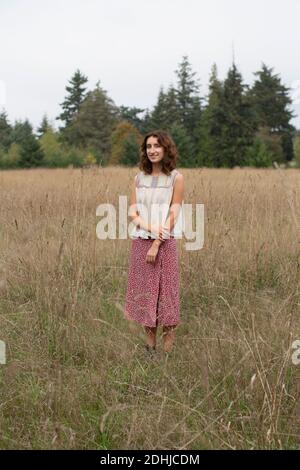 Portrait de bonne fille de dix-sept ans debout dans le champ de hautes herbes Banque D'Images