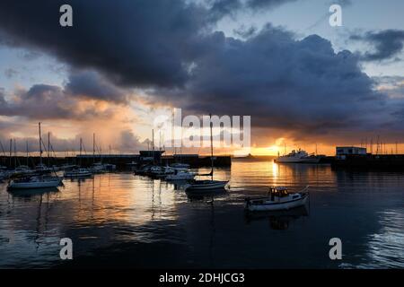 Le calme avant la tempête Alex, alors que le soleil se lève derrière le phare du port de Penzance le premier jour d'octobre. Banque D'Images