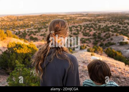 La girland adolescente son frère regardant vers le bas à Galisteo Basin, Santa Fe, NM au coucher du soleil Banque D'Images