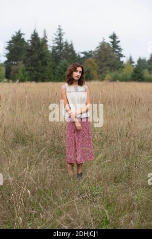 Portrait d'une jeune fille de dix-sept ans debout dans un champ de herbes hautes, Discovery Park, Seattle, Washington Banque D'Images