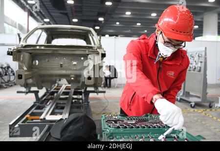 (201211) -- GUANGZHOU, le 11 décembre 2020 (Xinhua) -- UN candidat participe à un événement de maintenance automobile le deuxième jour du premier concours de compétences professionnelles de la République populaire de Chine qui s'est tenu à Guangzhou, dans la province de Guangdong, dans le sud de la Chine, le 11 décembre 2020. (Xinhua/lu Hanxin) Banque D'Images