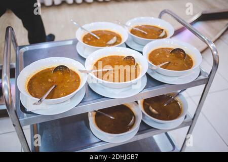 Une dose sélective de soupe chaude servie en blanc bols sur un chariot métallique Banque D'Images
