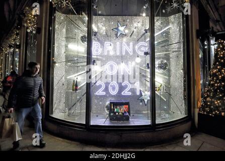 Un panneau « apportez 2021 » vu sur la fenêtre principale d'un magasin Harvey Nichols Knightsbridge à Londres. Autrefois connu comme la boutique préférée de la princesse Diana, le magasin Knightsbridge rayon Harvey Nichols est décoré pour Noël avec le message « apportez 2021 ». Banque D'Images