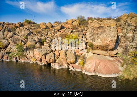 Parmi les grands rochers, un ruisseau brillant coule dans la lumière chaude du soir dans la pittoresque Ukraine. Banque D'Images