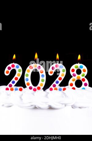 Quatre bougies blanches numéros flamme bonne année 2028 noir arrière-plan Banque D'Images