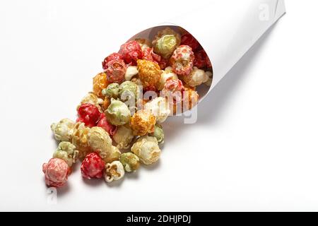 Grand angle de pop-corn savoureux coloré dans le cône en papier placé sur fond blanc en studio Banque D'Images