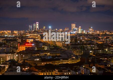Vue panoramique sur la ville de Madrid avec bâtiments résidentiels avec illuminés fenêtres la nuit dans un ciel sombre et nuageux Banque D'Images