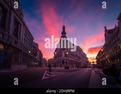 Angle bas du bâtiment Metropolis sur fond de coucher de soleil coloré Ciel à Madrid en longue exposition Banque D'Images
