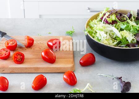 Salade de feuilles vertes dans un bol placé dans la table avec du frais tomates Banque D'Images