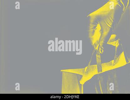 Liveur employeur dans des gants tenir le sac de papier d'artisanat avec la nourriture, tendance couleur de 2021.. Service quarantaine pandémie du coronavirus concept 2019-nc Banque D'Images