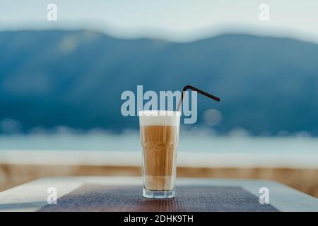 Verre à facettes avec latte de café et paille. Banque D'Images