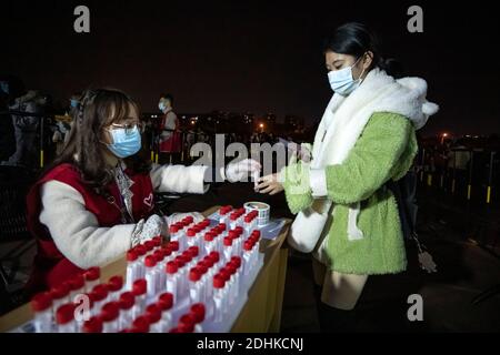 (201212) -- CHENGDU, 12 décembre 2020 (Xinhua) -- UN étudiant reçoit un test d'acide nucléique à l'Université de Xihua, dans le district de Pidu, dans la province du Sichuan, dans le sud-ouest de la Chine, le 11 décembre 2020. Vendredi, à Chengdu, dans le sud-ouest de la Chine, a lancé une campagne de dépistage des acides nucléiques, offrant des tests gratuits à tous les résidents du district de Pidu, où plusieurs nouveaux cas de COVID-19 ont vu le jour depuis le début de la semaine. Le quartier général de la prévention et du contrôle COVID-19 du district a déclaré que le trajet a commencé à 6 h, les frais d'essais étant couverts par le gouvernement du district. (Xinhua/Shen Bohan) Banque D'Images