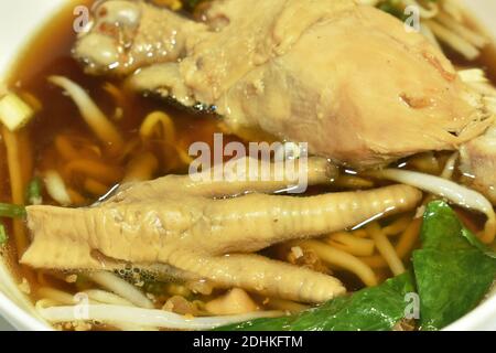 cuisse et pieds de poulet bouillis avec fève de spout dans une soupe aux herbes sur un bol Banque D'Images