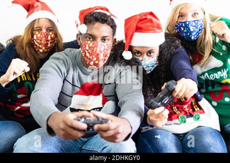 Les gens du millénaire s'amusent avec la console de jeux vidéo à l'heure de noël. Toute la famille jouant à des jeux vidéo toute la journée dans l'appartement pour le verrouillage. Noël, Banque D'Images