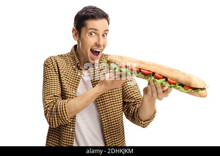 Joyeux jeune homme excité mangeant un long sandwich dans un pain de baguette isolé sur fond blanc Banque D'Images