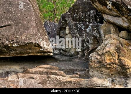 Des images sculptées à la main de Bouddha et d'autres décorations trouvées dans des formations rocheuses dans la zone isolée dans le temple ouvert de Bouddha. Banque D'Images