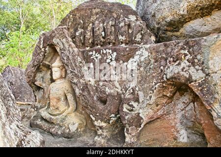 Des images sculptées à la main de Bouddha et d'autres décorations trouvées dans des formations rocheuses dans la zone isolée dans le temple ouvert de Bouddha. Banque D'Images