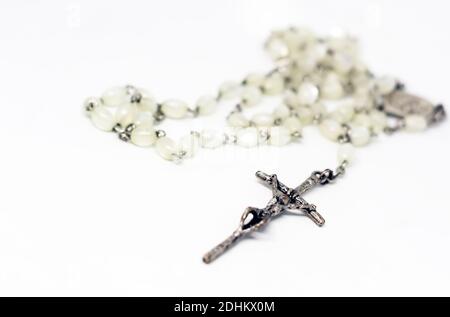 Rosaire de perle blanche avec crucifix d'argent isolé sur fond blanc. Prière et dévotion. Objet religieux. Banque D'Images