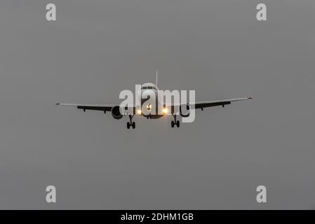 Arrivée en début de matinée. Avion de ligne à réaction en approche pour atterrir à l'aéroport de Londres Heathrow, Royaume-Uni, pendant la pandémie COVID 19. Lever du soleil couvert, feux d'atterrissage Banque D'Images