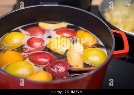 Préparation de délicieux cidre chaud à la cannelle dans une casserole rouge. Gros plan sur une recette de fête. Banque D'Images