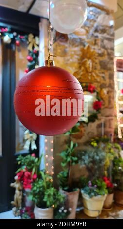 Boule de Noël rouge avec pots de fleurs flous en arrière-plan Banque D'Images