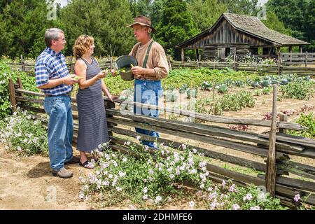 Alabama Dothan Landmark Park Living History Farm 1890's, visiteurs fermier montrant expliquant homme femme couple jardin, Banque D'Images