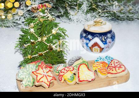 Biscuits faits maison avec glaçage sur fond de sucre en poudre et de décorations de Noël. Mise au point sélective Banque D'Images