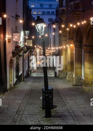 Les vieilles boutiques traditionnelles sont éclairées à l'aube sur la pittoresque rue Christmas Steps de Bristol. Banque D'Images