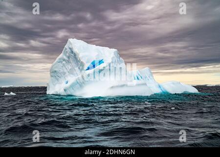 Iceberg de fusion avec banc de glace en premier plan, flottant dans la mer, à l'Antarctique. Banque D'Images