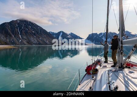 Voilier et équipage explorant le madgalenefjorden, nord-ouest du Spitsbergen, Svalbard, Norvège en août. Banque D'Images