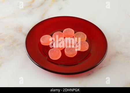 Sucrée de délicieux morceaux de bonbons pastèque sur une petite assiette de dessert rouge sur la table Banque D'Images