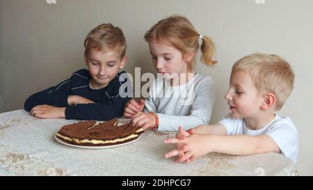 Les enfants heureux sont prêts à manger des gâteaux. Banque D'Images