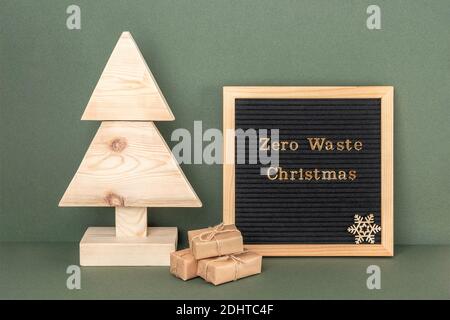 Zéro gaspillage texte de Noël sur le tableau de lettres. Arbre de Noël en bois fait maison et cadeaux sur fond vert. Concept xmas zéro déchet, écologique. Avant Banque D'Images