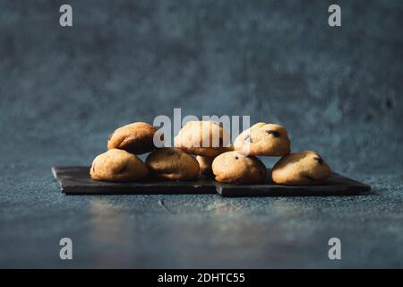 Petits biscuits aux pépites de chocolat servis sur une élégante assiette noire - collations gastronomiques Banque D'Images