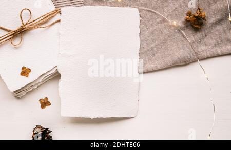Maquette de lettre vierge sur papier artisanal. Enveloppe de lettre, cônes de pin, fil d'artisanat et bougie. Tons pastel, beige, style confortable en hygge. Plat, dessus Banque D'Images