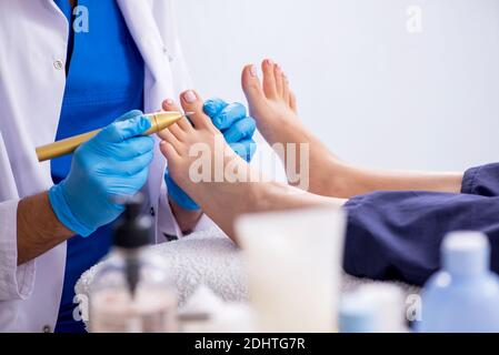 Podiatre traitant les pieds pendant la procédure Banque D'Images