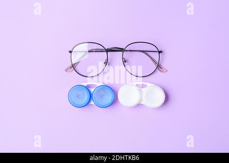 Récipients avec verres de contact et lunettes sur fond de couleur Banque D'Images