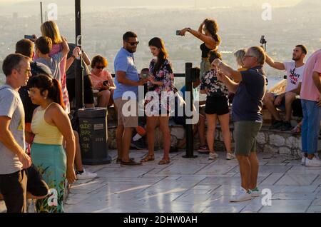 Les touristes prennent des photos sur leurs smartphones au point de vue sur la colline du Lycabette dans le centre d'Athènes en Grèce - photo: Geopix Banque D'Images