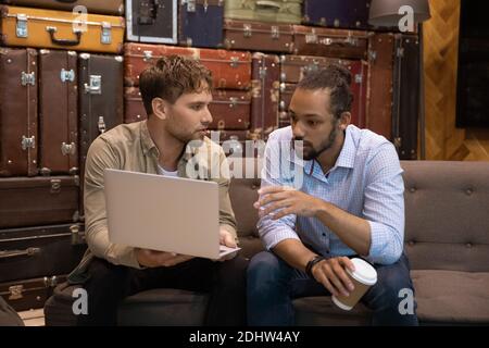 Des collègues multiraciaux réfléchissent à travailler ensemble sur un ordinateur portable Banque D'Images