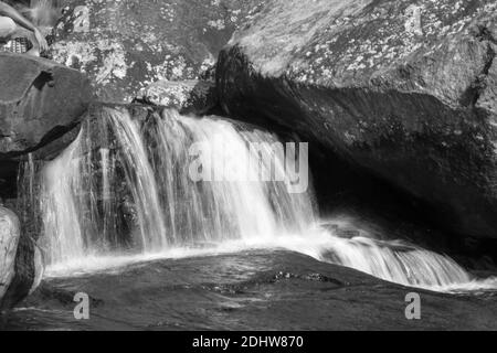 Paysages charmants d'une formation de roche et d'une chute d'eau dans un ruisseau de montagne d'eau douce. Le regard vitreux sur l'eau rend la scène paisible et sereine Banque D'Images